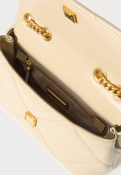 Κρέμα δερμάτινη τσάντα χειρός με επενδυμένο σχέδιο, χρυσό αλυσίδα ώμου, ορθογώνια κλείσιμο και εσωτερική τσέπη με φερμουάρ με επένδυση από ύφασμα.