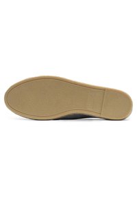 Semelle de chaussure noire avec une surface texturée et une forme courbée. Matériau en caoutchouc marron clair avec des bords lisses et un détail de marque subtil.