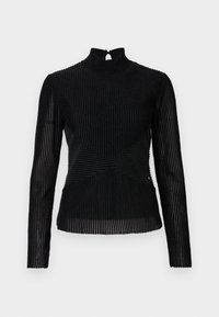 Musta tiukka yläosa, jossa on pitkät hihat, korkeakauluksinen design ja takana avainaukko. Nukkakuvioinen ribbitekstuuri ja vino sauma-yksityiskohtia.