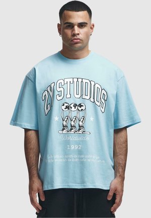 Light blue oversized t-shirt made of cotton. Features bold black text and graphic prints of three figures holding globes, with white accents.