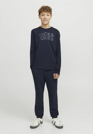 Tengerészeti, hosszú ujjú póló, amelyen a "JACK & JONES" logó található, összeillő melegítőnadrággal párosítva. Mindkettő puha, kényelmes anyagból készült. Magasított sportcipő viselése.