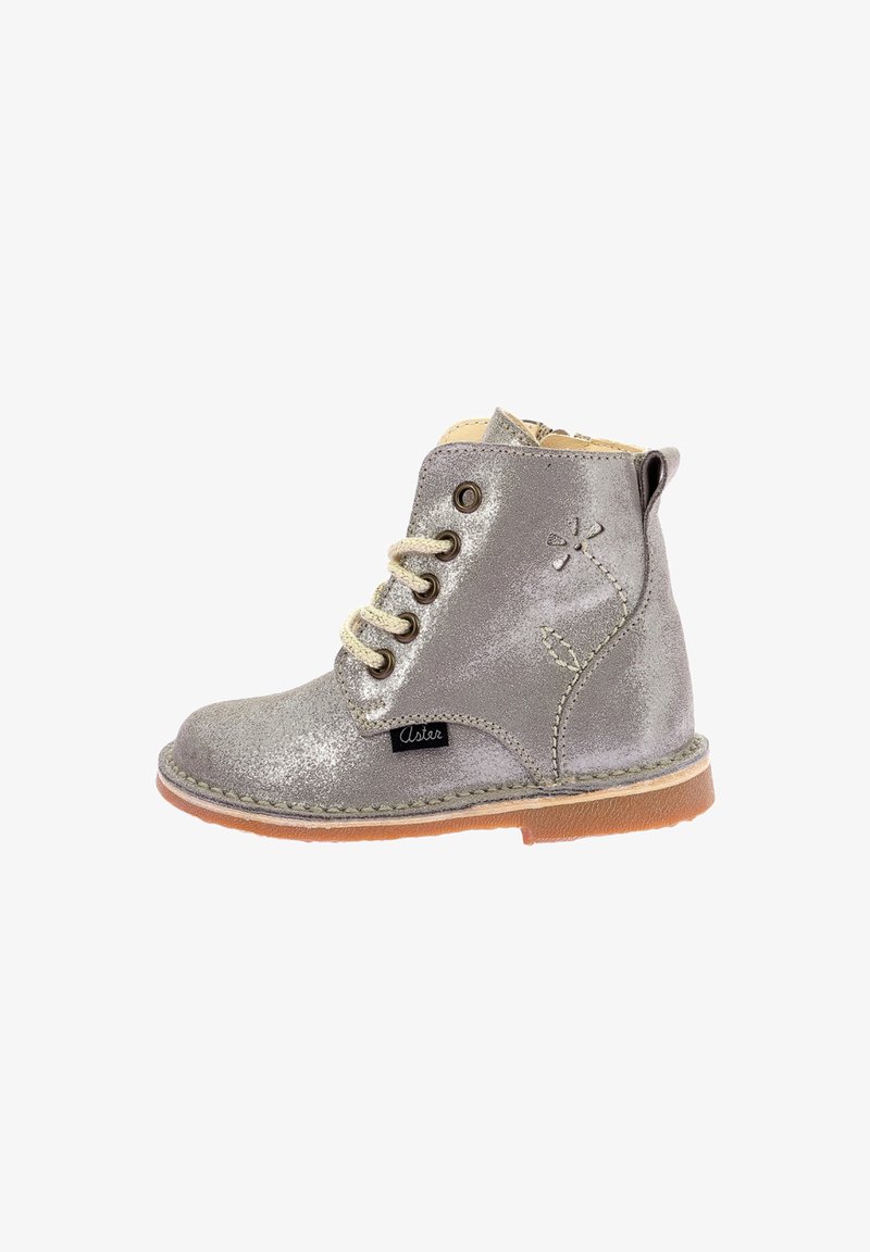 Bottines à paillettes argentées pour enfants avec lacets beiges, semelle marron, fermeture éclair sur le côté et motif de fleur cousu sur le côté extérieur.