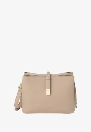 Beige bőr kézitáska puha textúrával, arany hardware kiegészítőkkel, cipzáras záródással és állítható pánttal. Minimalista dizájn és logó részlet jellemzi.