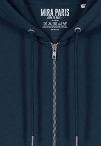 Felpa blu navy con zip frontale, cordini e hardware in argento. Materiale 100% cotone. Presenta un'etichetta del marchio sul colletto.