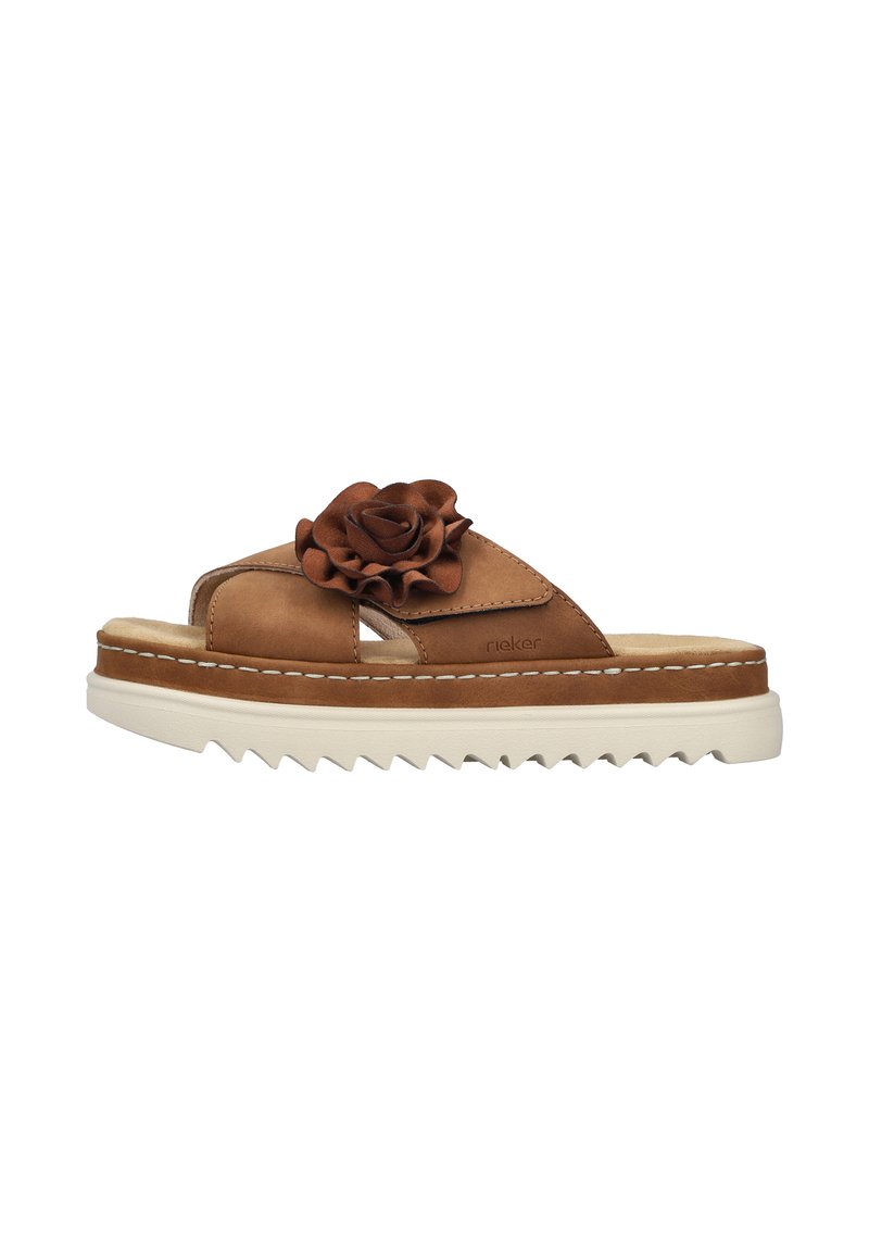 Tan leather slide sandals with a decorative brown flower on the strap, textured footbed, and chunky white serrated sole.
