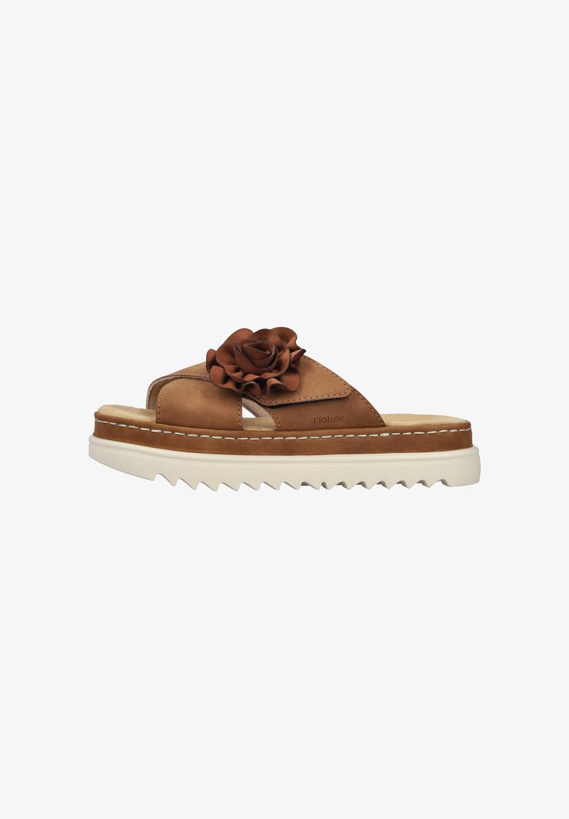 Tan leather slide sandals with a decorative brown flower on the strap, textured footbed, and chunky white serrated sole.