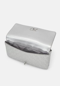Borsa clutch in ecopelle argentata con logo impressa, fodera interna liscia e chiusura magnetica. L'interno presenta una discreta stampa del marchio.
