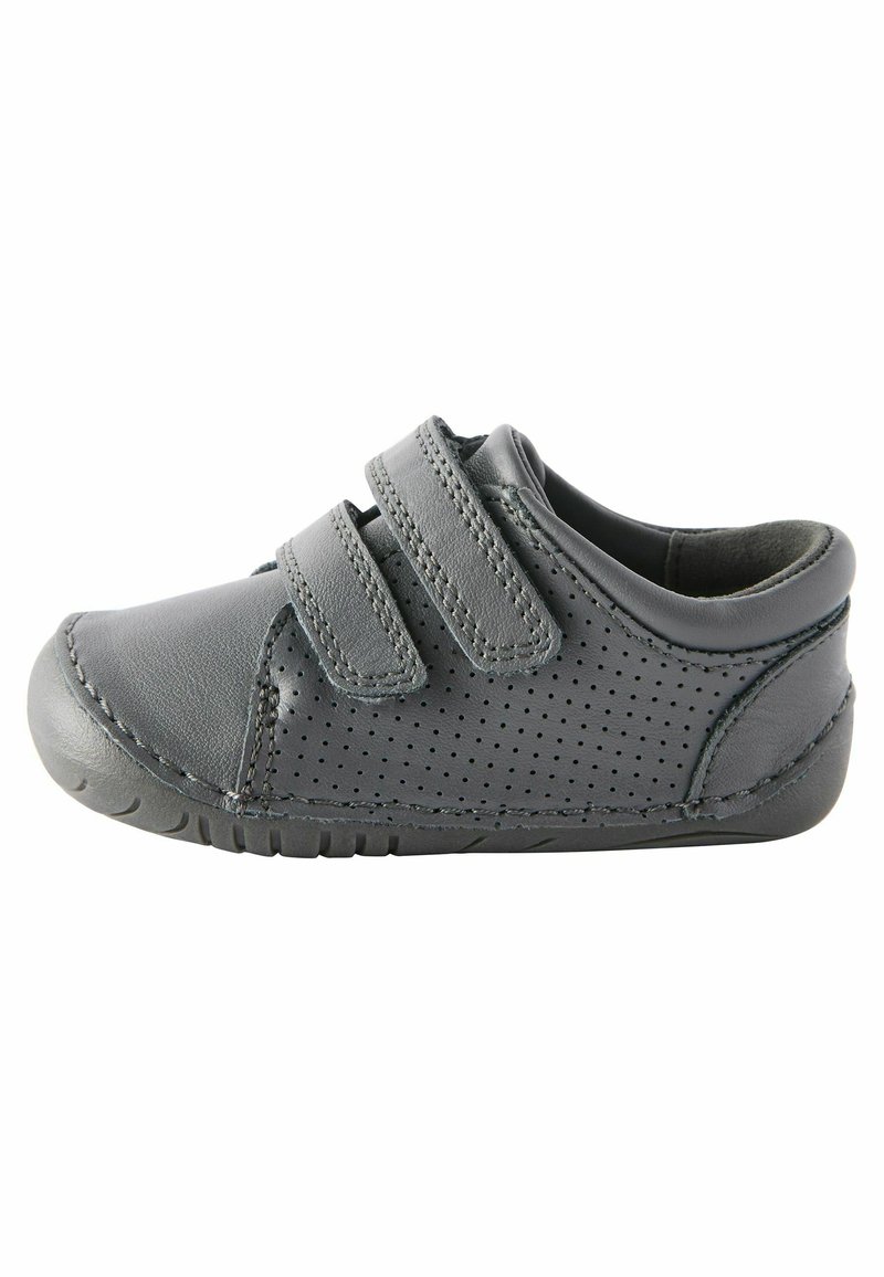 Chaussure en cuir gris avec deux bandes Velcro, design perforé sur le côté, bout rond et semelle en caoutchouc flexible.