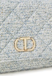 Quilted blue tweed bag with metallic thread accents; features a gold-tone hardware closure with "TWINSET" engraving.