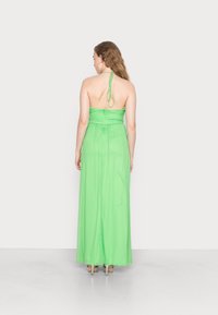 Vestido maxi em verde claro transparente, design de halter neck, corpete franzido, saia fluida. Ties ajustáveis no pescoço, textura suave, comprimento até ao chão.