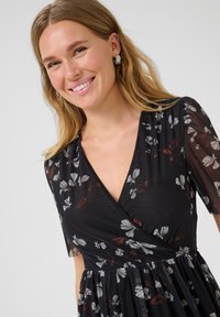 Rochie cu imprimeu floral lungă în negru, cu mâneci scurte dintr-un material transparent; prezintă modele florale în alb și burgund; țesătură moale, texturată.