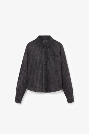 Čierny skrátený top s vertikálnymi pruhmi, zapínaním na gombíky, jednou náprsnou vreckom a textúrovanou látkou s jemným leskom.