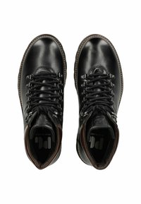 Botas de senderismo de cuero negro con punta redonda, diseño de cordones, ojales de metal y acentos marrones que contrastan en el cuello y la suela.