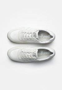 Baskets de sport blanches en cuir et tissu, dotées d'un système de lacets, d'accents texturés et d'un logo sur la languette. Fini lisse.