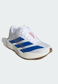 Chaussure de sport blanche avec des rayures bleues, semelle rembourrée et étiquette "ADIZERO" sur la languette, présentée sur un fond gris clair.