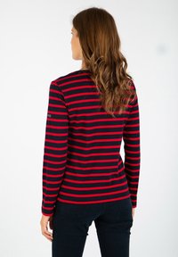 Langsleeve shirt in marineblauw met rode horizontale strepen. Beschikt over een ronde halslijn en een getailleerde pasvorm. Gladde textuur, casual ontwerp.