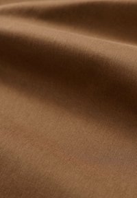Tessuto marrone con una superficie liscia e uniforme e una leggera lucentezza, che mette in mostra una superficie consistente e una fine rilassatura.