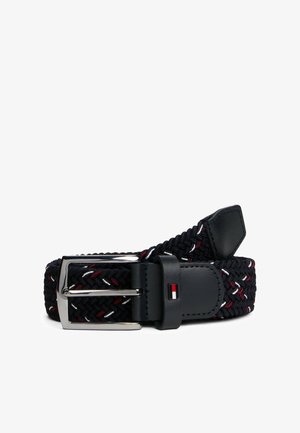 Ceinture en tissu tissé bleu marine avec des accents rouges et blancs. Dotée d'une boucle en métal argenté et d'une sangle en cuir noir pour les ajustements.