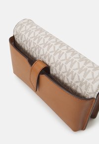 Brązowy skórzany portfel z zamknięciem na materiał w beżowym wzorze. Posiada zapięcie na zatrzask oraz gładką teksturę skóry i materiału.