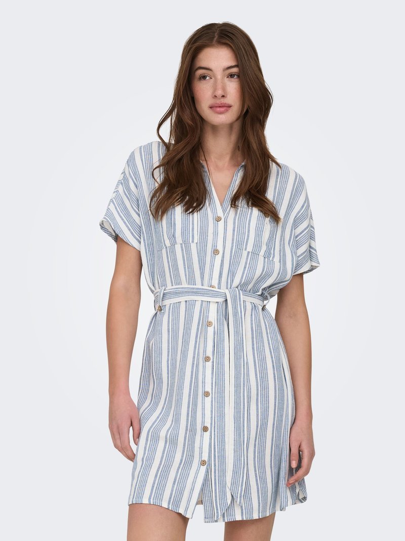 Jeune femme portant une robe à manches courtes, cintrée avec ceinture, boutonnée sur le devant, à rayures verticales bleues et blanches sur un fond uni.