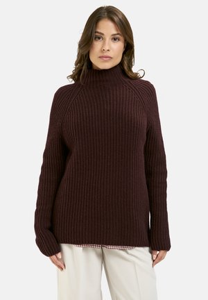 Burgunderfarbener Ripp-Strickpullover mit hohem Kragen, langen Ärmeln und seitlichen Schlitzungen, der ein strukturiertes Muster aufweist.