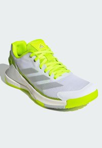 White athletic shoe with neon green accents, lightweight mesh upper, textured fabric, and a flexible rubber sole. Marked with three stripes.