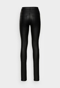 Jeans pretos, de corte justo, com um acabamento suave, apresentando uma cintura média, dois bolsos traseiros e detalhes de costura discretos.