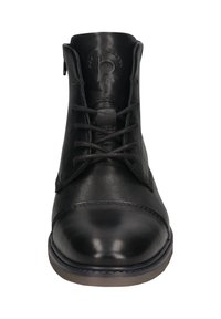 Bottine en cuir noir avec bout rond, devant à lacets et logo en relief sur la languette, vue de face.