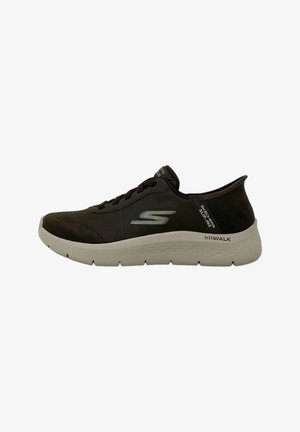 Scarpe da ginnastica nere in suede con una trama liscia, suola grigio chiaro e un logo sul lato. Le caratteristiche includono lacci e un design slip-on.