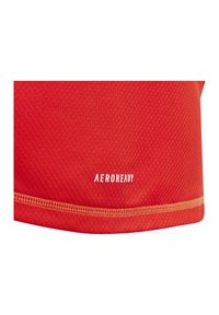 Rood sporttop met een gestructureerd honingraatpatroon. Geaccentueerd met de "AEROREADY" branding in het wit nabij de zoom.