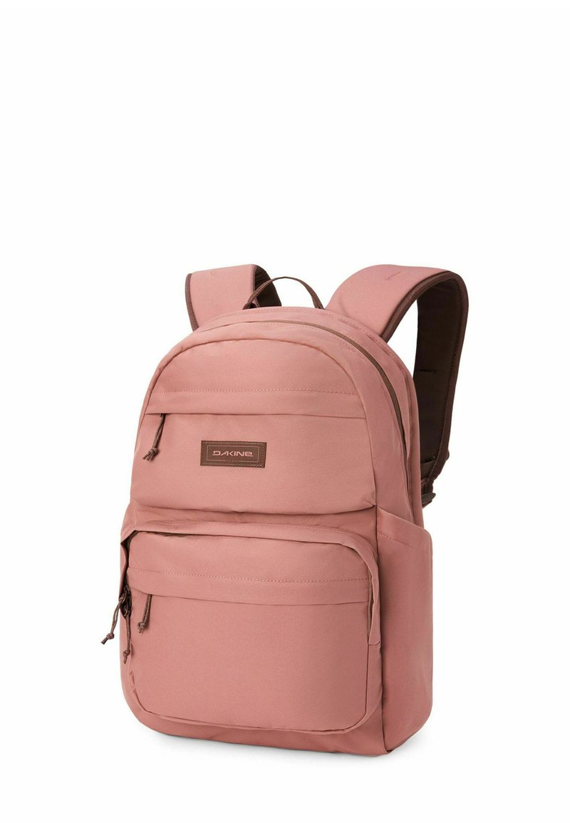 Mochila Dakine rosa con dos compartimentos con cremallera y correas acolchadas para los hombros, mostrada sobre un fondo blanco.