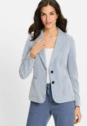 Blazer rayé en tissu en coton bleu et blanc, avec un col cranté, deux boutons et des poches avant, associé à un pantalon décontracté.