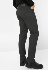Grijze nauwsluitende broek van gestructureerde stof, met een slim fit, een vlakke voorkant en een standaard vijf-pocket ontwerp, gecombineerd met zwarte schoenen.