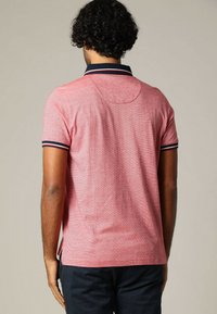 Rode poloshirt met korte mouwen, voorzien van een marineblauwe kraag en gestreepte mouwen, textiel met textuur en een afgeronde achterzoom.