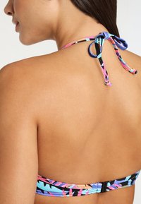 Colorful bikini top featuring a multicolored tropical pattern, adjustable straps, and a clasp at the back. Material appears stretchy and smooth.