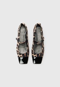 Chaussures à imprimé léopard avec une texture douce, bouts en vernis noir et détail de bride au niveau de la cheville. Forme carrée avec semelles rembourrées pour le confort.