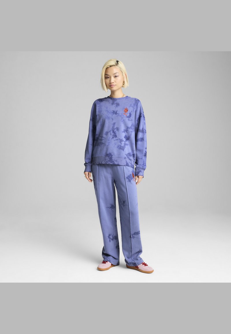 Felpa con tie-dye viola e pantaloni abbinati, caratterizzati da un design ricamato. Il tessuto sembra morbido, con una vestibilità comoda e maniche lunghe.