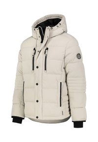 Beige padded jacket with a high collar, black accents, zippered pockets, and ribbed cuffs. Features a logo patch on the sleeve.