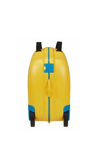 Valise rigide jaune avec des accents bleus, roues noires, poignée centrale et courtes sangles noires sur fond blanc.