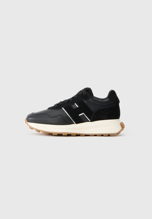 Czarne sneakersy z połączeniem gładkiej skóry i zamszu. Wyposażone w białe akcenty logo, czarne sznurówki oraz gumową podeszwę zapewniającą przyczepność.