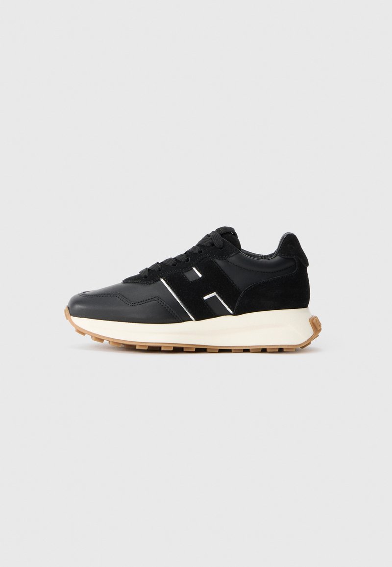 Adidași negri cu o combinație de piele netedă și velur. Dispune de un logo accent alb, șireturi negre și o talpă din cauciuc pentru aderență.