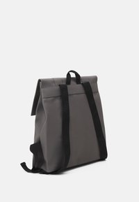 Sac à dos gris au design structuré, fabriqué en matériau lisse. Doté de bretelles noires et d'une fermeture roulée pour un stockage sécurisé.