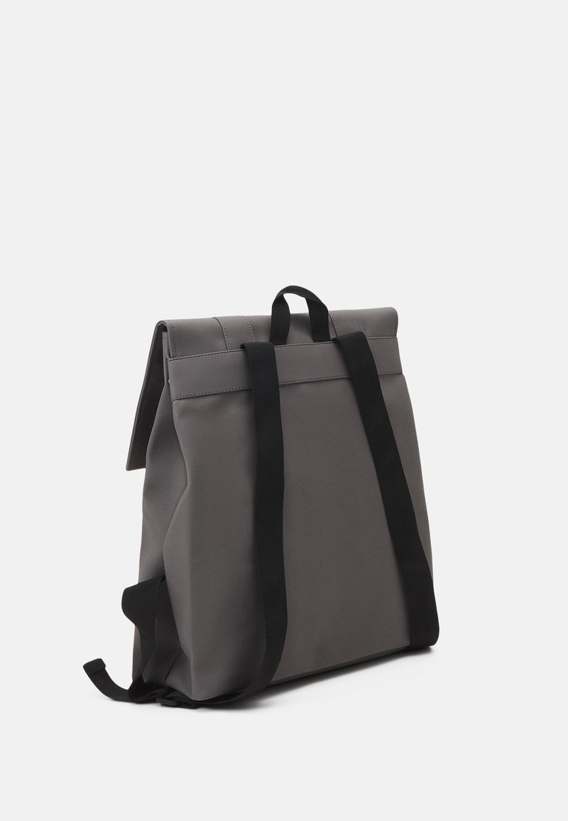 Zaino grigio con un design strutturato, realizzato in materiale liscio. Presenta spallacci neri e una chiusura arrotolata per una conservazione sicura.