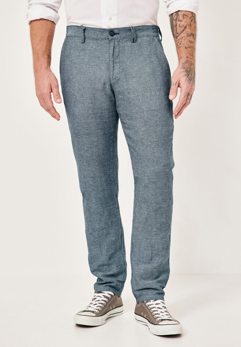 Light blue linen trousers with a smooth texture, straight cut, and a single button closure, paired with gray sneakers.
