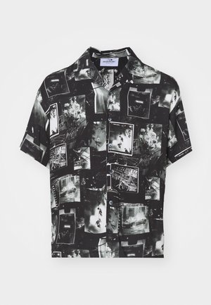 Camicia a maniche corte nera con un collage di fotografie in bianco e nero, dotata di chiusura con bottoni e colletto classico. Tessuto texturizzato.
