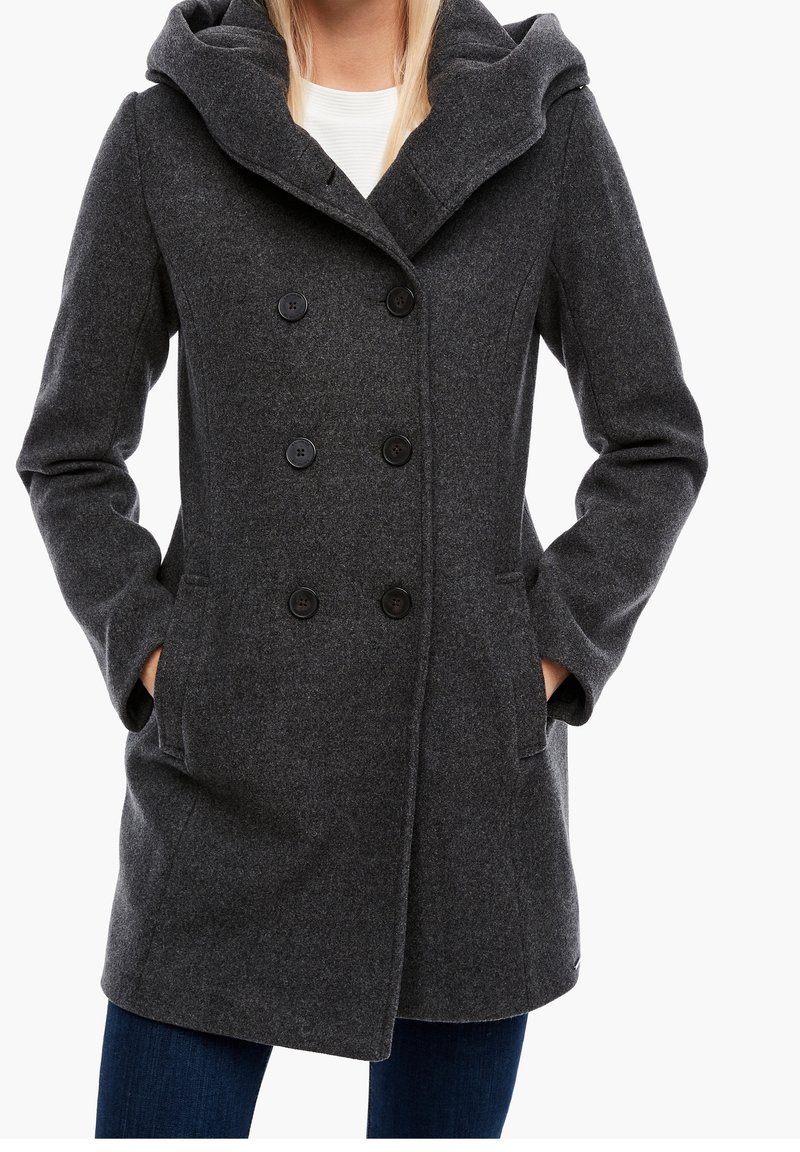 Cappotto grigio in misto lana con un ampio cappuccio, chiusura doppiopetto con bottoni e tasche laterali. Presenta un tessuto testurizzato e una vestibilità sartoriale.