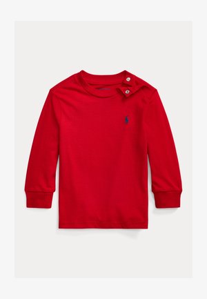 Czerwona koszulka z długim rękawem wykonana z bawełny, z okrągłym dekoltem i zapięciem na zatrzaski na ramieniu. Posiada małe niebieskie logo.