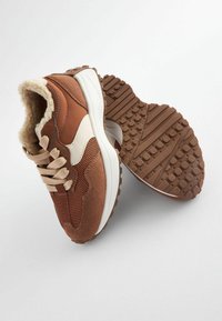 Sneakers marroni con texture in rete e camoscio, con accenti beige, una fodera morbida e una suola in gomma con un grip a motivo.
