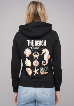 Black hoodie featuring a colorful graphic of seashells, a crab, a seahorse, and coral on the back, with "THE BEACH Club" text above.