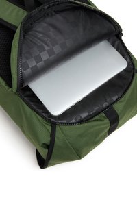 Zielony plecak z tkaniny z zamkiem błyskawicznym, posiadający czarne wnętrze i częściowo widoczny srebrny laptop w środku.